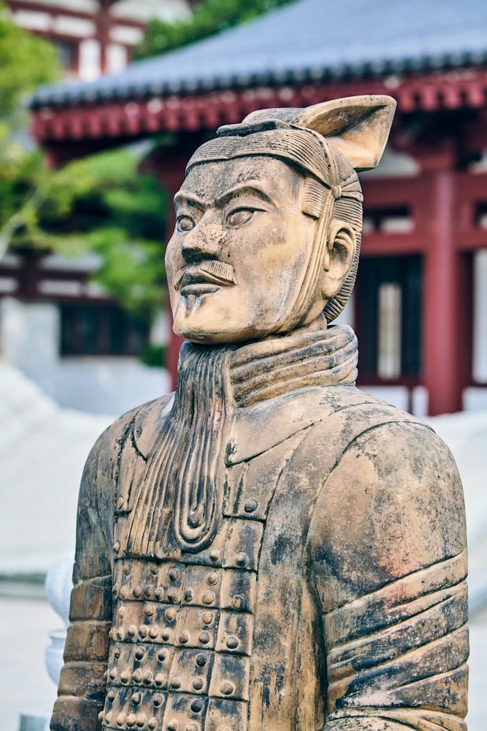 gallery-6 Close-up of a terracotta warrior statue set in an ancient Chinese architectural background.