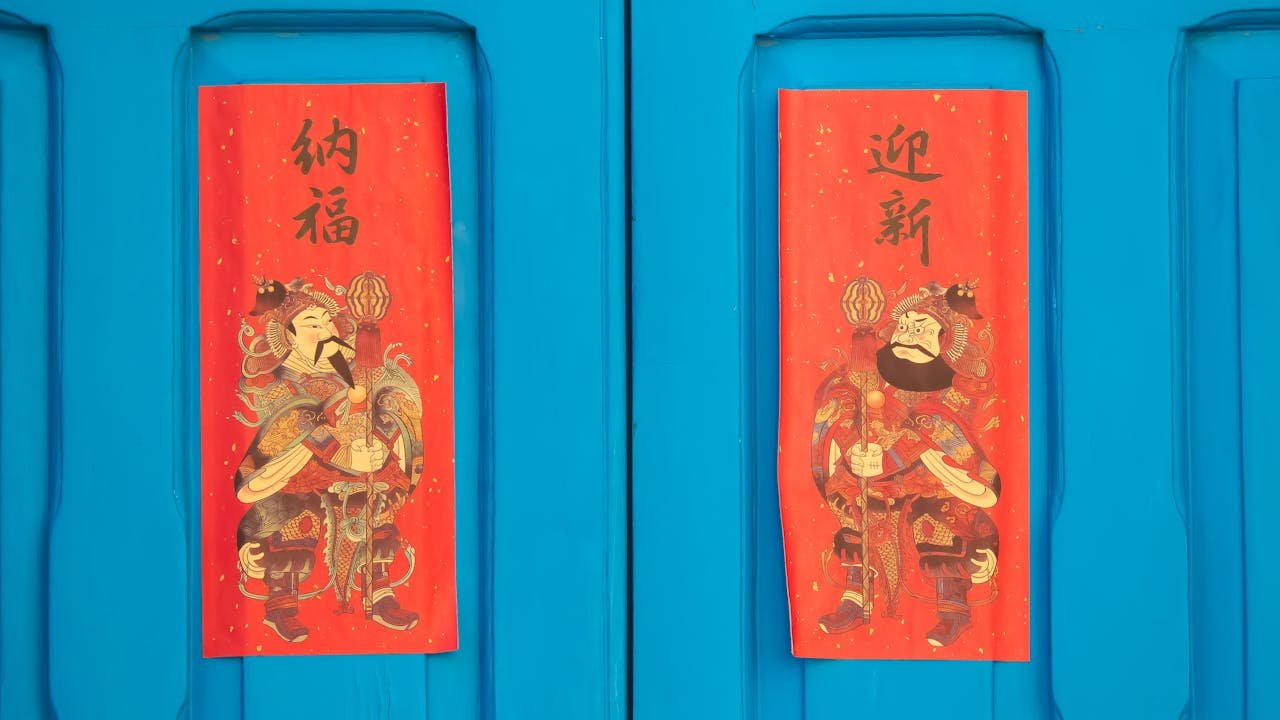 why-choose-us Bright red Chinese New Year decorations on a blue door symbolize good fortune and prosperity.
