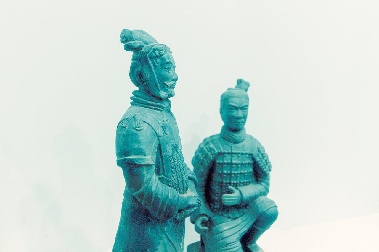 hero-img-02 Two terracotta warrior statues displayed on a white backdrop.